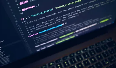 A close-up of source code displayed on a laptop